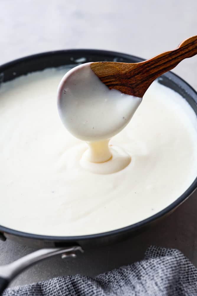 Bechamel sauce is just the creamy, dreamy sauce you need in your life! It's smooth and velvety and can be used in a variety of dishes, from mac and cheese to lasagna. Once you get a taste of its creamy, subtly savory flavor, you'll be hooked! Hero image of bechamel sauce in a black saucepan.