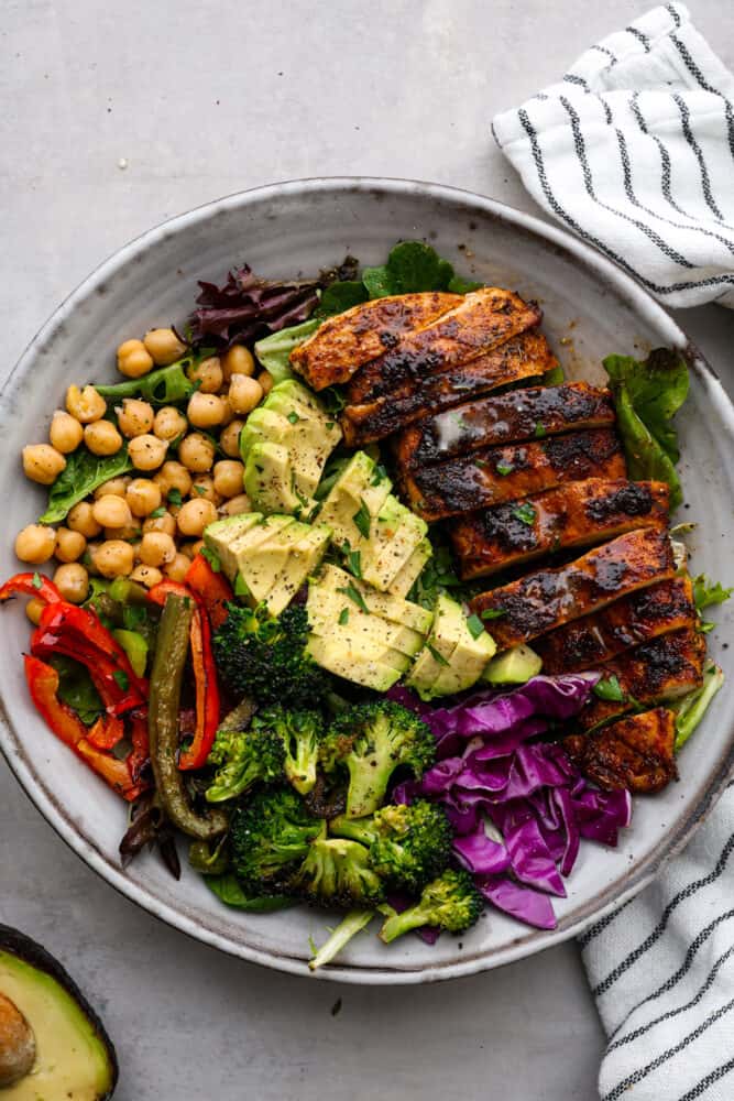Blackened Chicken Avocado Power Bowls have the best spiced rubbed blackenendย chicken with so many power foods! Avocado, chickpeas, red cabbage and roasted veggies come together in this healthy and flavorful bowl!ย