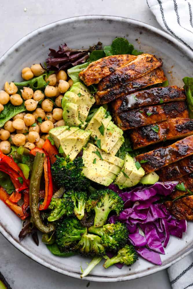 Blackened Chicken Avocado Power Bowls have the best spiced rubbed blackenendย chicken with so many power foods! Avocado, chickpeas, red cabbage and roasted veggies come together in this healthy and flavorful bowl!ย