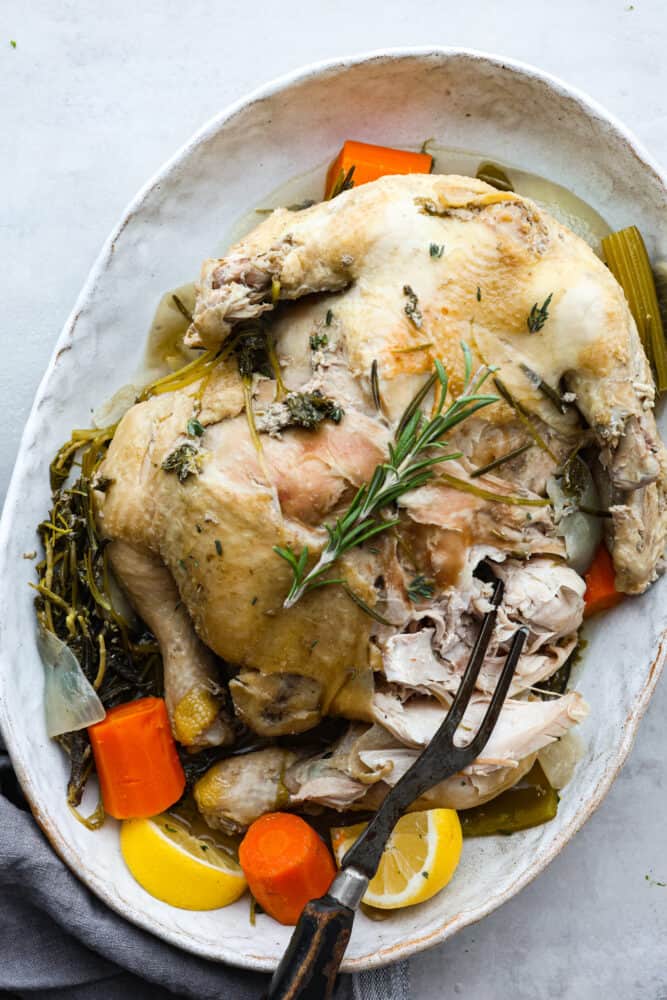 Learning how to boil a whole chicken is a great skill to have in your back pocket, especially if you're trying to eat clean or meal prepping! This boiled chicken is flavorful, juicy, and can easily be transformed into a one-pot meal. Shredding a whole boiled chicken.