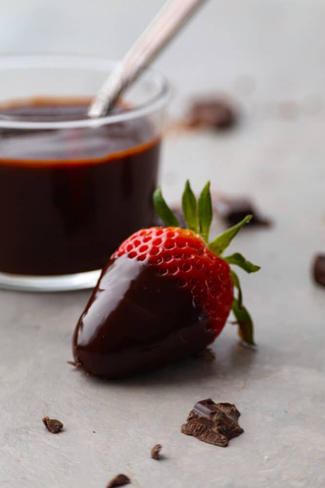 Everyone needs a great chocolate ganache recipe in their cookbook! This recipe is a classic and the best ganache recipe I've ever tried. It's perfectly shiny with rich chocolate flavor, and takes 5 minutes to whip up! A strawberry dipped in chocolate ganache.