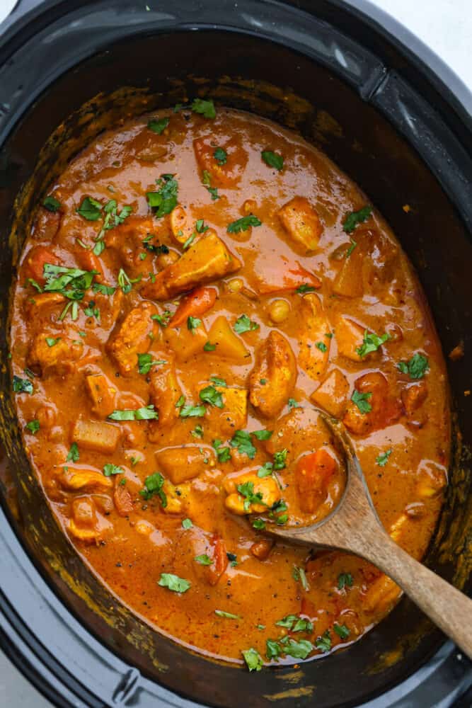 Coconut curry chicken is a mouthwatering dish that combines tender chicken, hearty vegetables, and a blend of aromatic spices, all simmered in a luscious coconut milk sauce. Serve it up with naan and basmati rice for a meal your family won’t be able to get enough of! Coconut curry chicken in a slow cooker.