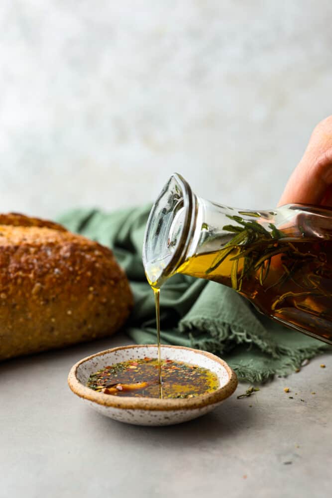 If you're anything like me, then you know that garlic is one of the best ingredients in the kitchen. And when you infuse it into some good quality olive oil, well, get ready for some serious magic! Pouring garlic infused olive oil into a small dish.