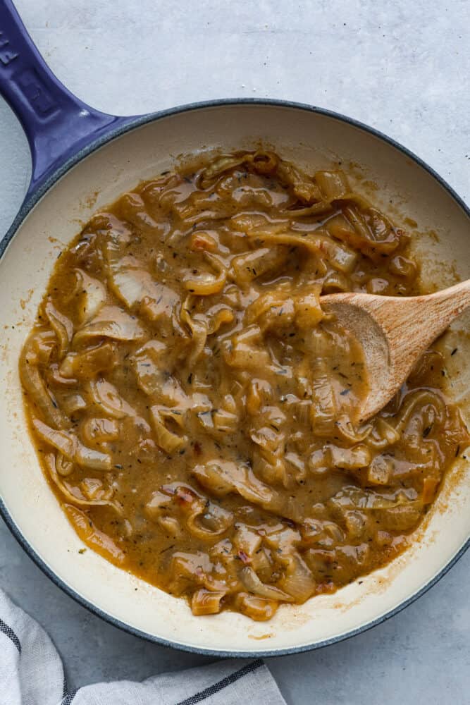 This onion gravy is hands-down the BEST! It's rich, savory and filled with sweet, caramelized onions that really take it to the next level. Hero image of onion gravy in a blue and white skillet.