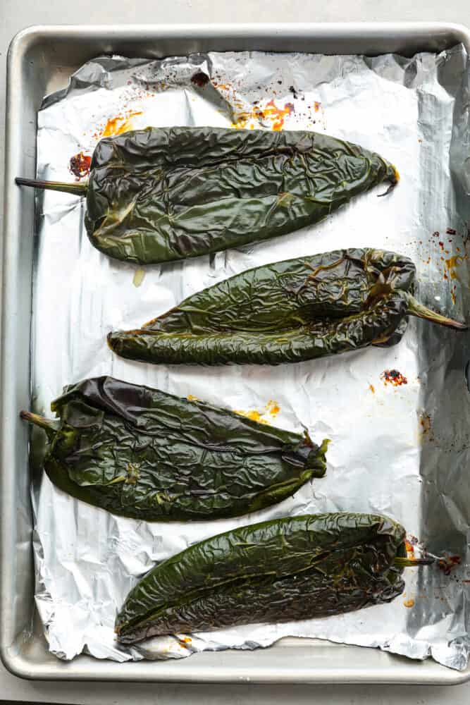 If you're a fan of peppers and haven't tried roasted poblano peppers yet, you're missing out! These peppers have a unique flavor that is smoky, slightly sweet, and just a little bit spicy. Roasting them brings out their full potential, making them perfect for giving your favorite Mexican dishes a little kick. 4 poblano peppers after being roasted.