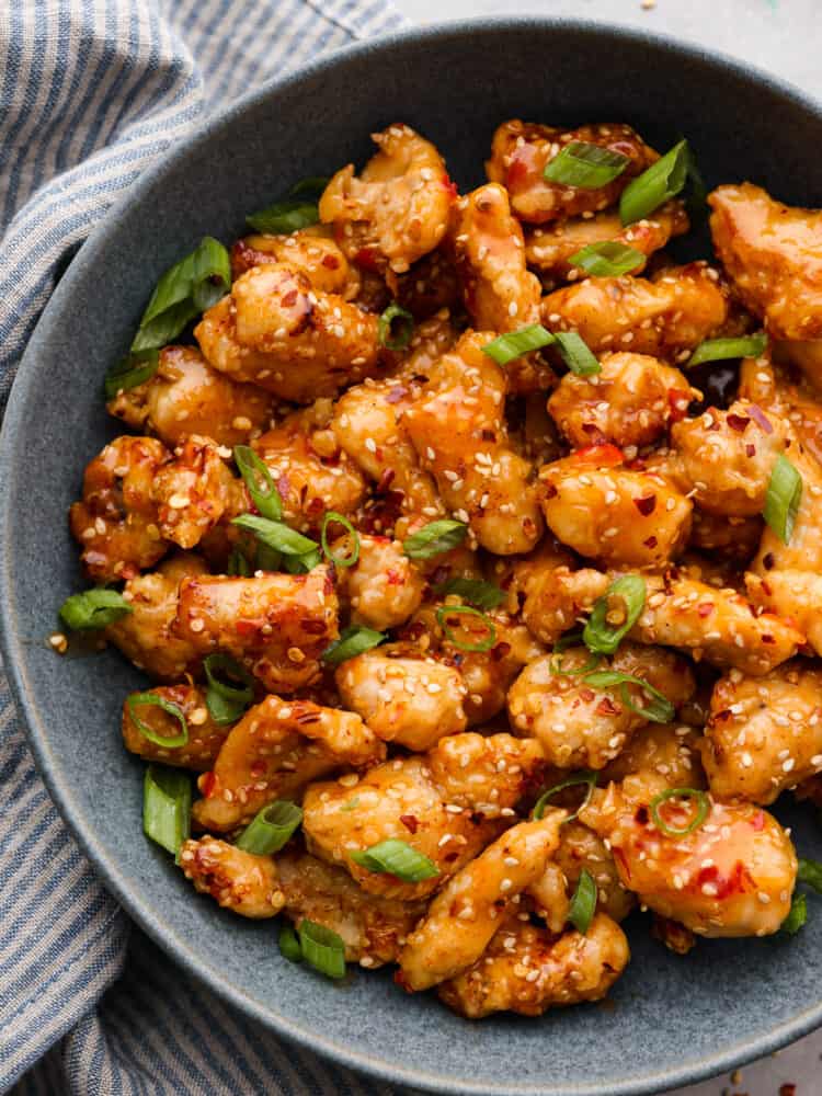Bring a bang to your dinner table with this explosive bang bang chicken! Itโs crispy but tender and coated in a thick, creamy sauce thatโs savory, spicy, and sweet all at once! Closeup of bang bang chicken.