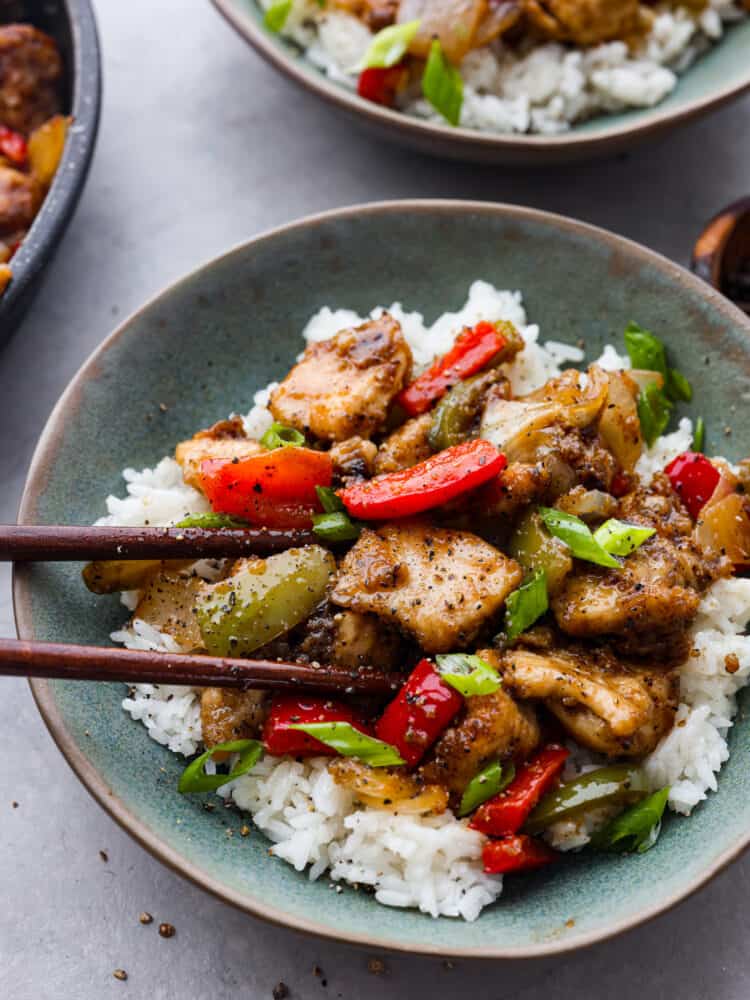 If you want to add a burst of flavor to weeknight dinners, this Chinese-inspired black pepper chicken is the perfect recipe to try! With its amazing homemade sauce, each bite is packed with savory, peppery, and slightly tangy flavors that will leave your mouth watering. Closeup of black pepper chicken served over white rice.