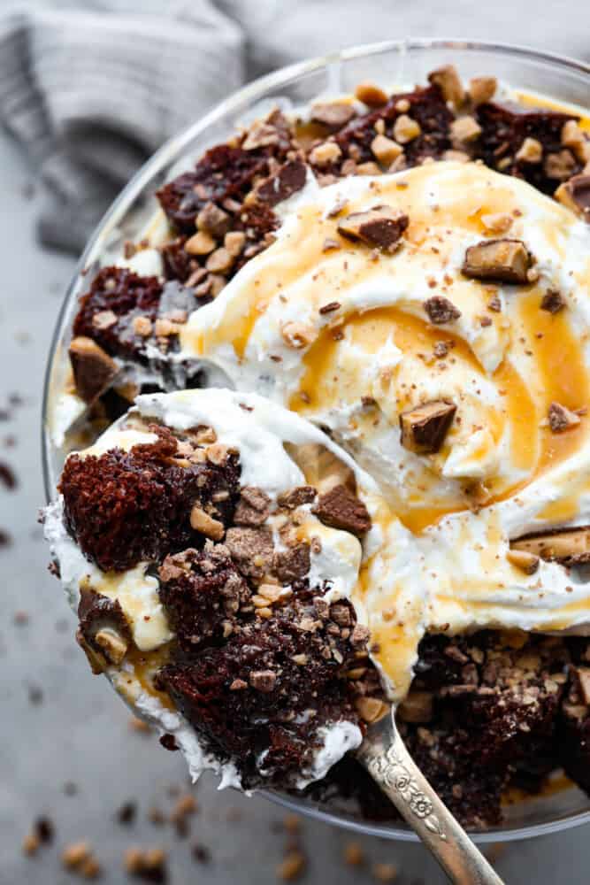 A classic English dessert that is every chocolate loverโs dream! This chocolate trifle is made with layers of devilโs food cake, caramel sauce, whipped cream, and toffee bits that will have you savoring each and every bite. Taking a bite of chocolate trifle.