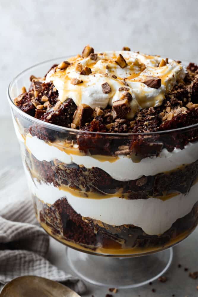 A classic English dessert that is every chocolate loverโs dream! This chocolate trifle is made with layers of devilโs food cake, caramel sauce, whipped cream, and toffee bits that will have you savoring each and every bite. Chocolate cake, whipped cream, caramel, and crushed toffee bits in a trifle dish.