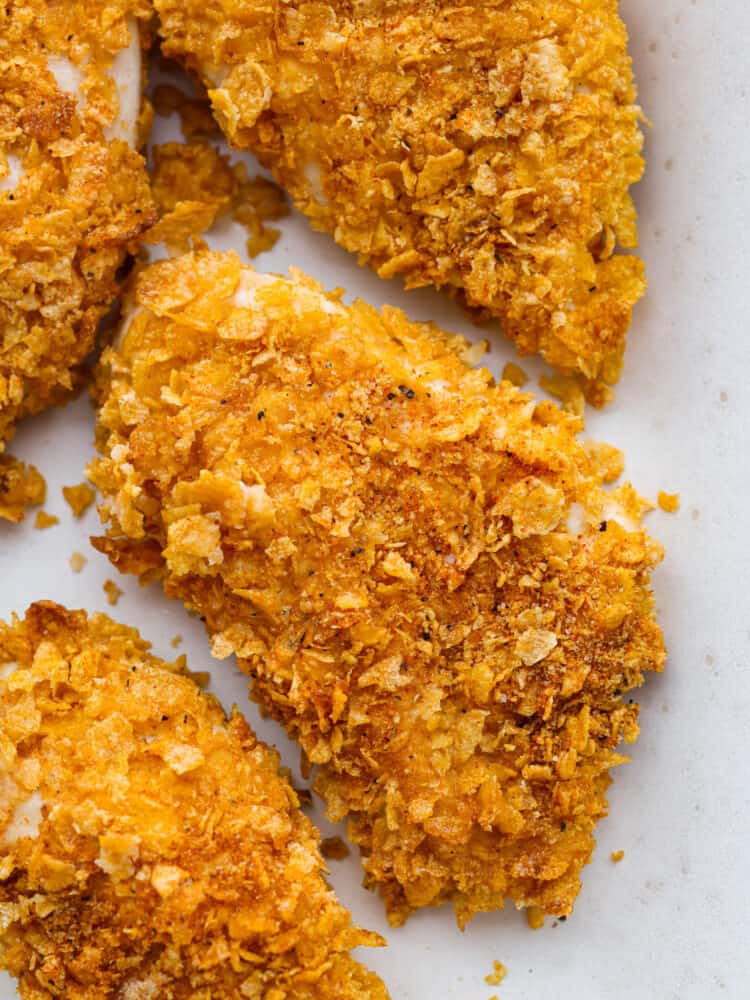 Ultra crispy-and so delicious, cornflake chicken is just the easy you dinner you need this week! Each chicken breast is coated in cornflakes and savory seasonings for both the best texture and flavor! Closeup of cornflake chicken.