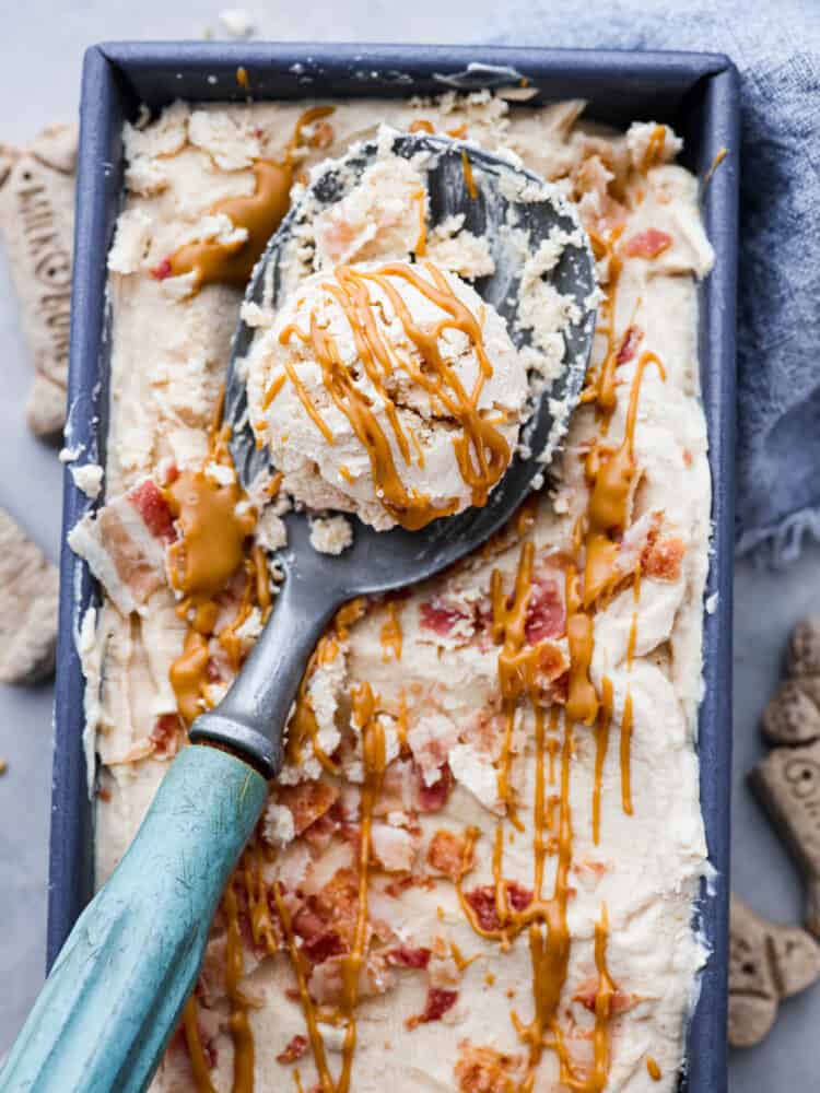 Keep your pup cool and happy this summer with a scoop of dog ice cream! This frosty treat is made with peanut butter, banana, and plain yogurt, topped with crispy bacon bits. Your fur baby won't be able to get enough. Closeup of dog ice cream.