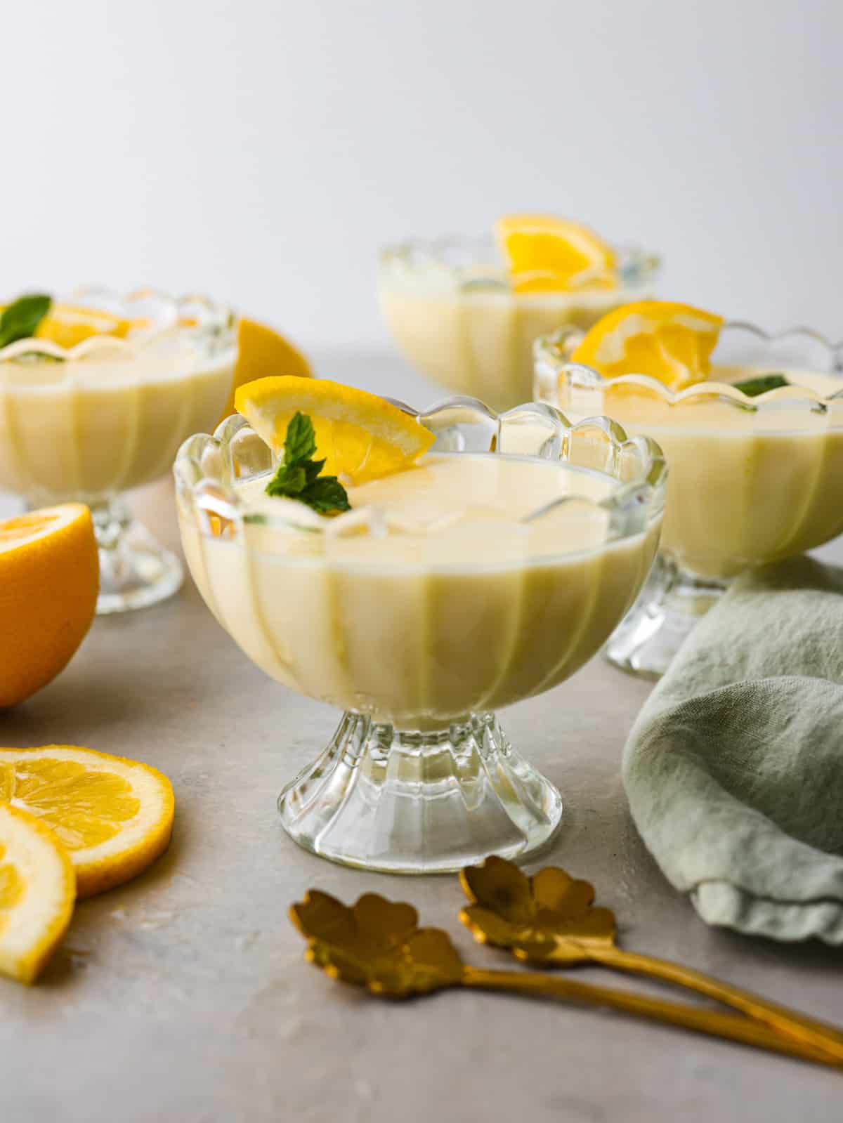 Lemon Posset- Only 5 Ingredients! Lemon posset in a glass serving dish garnished with fresh lemon wedge and sprig of fresh mint.