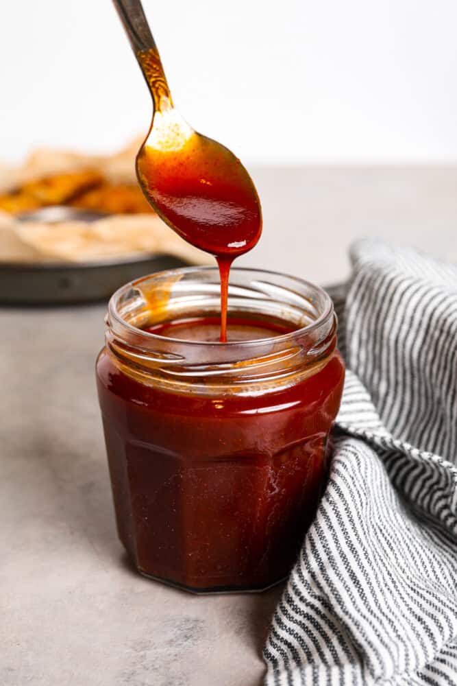Mumbo sauce is like a dreamy combination of barbecue and sweet and sour sauce. It’s tangy and savory with a glaze-like texture that’s wonderful for coating chicken wings! Hero image of mumbo sauce in a glass jar.