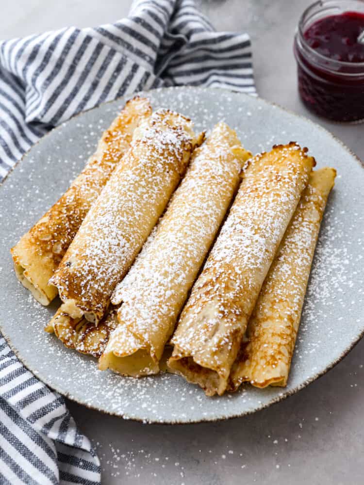 Homemade Swedish pancakes are the ultimate breakfast treat! They're soft, tender, and even better when topped with fresh whipped cream and lingonberry jam. Multiple Swedish pancakes dusted with powdered sugar.