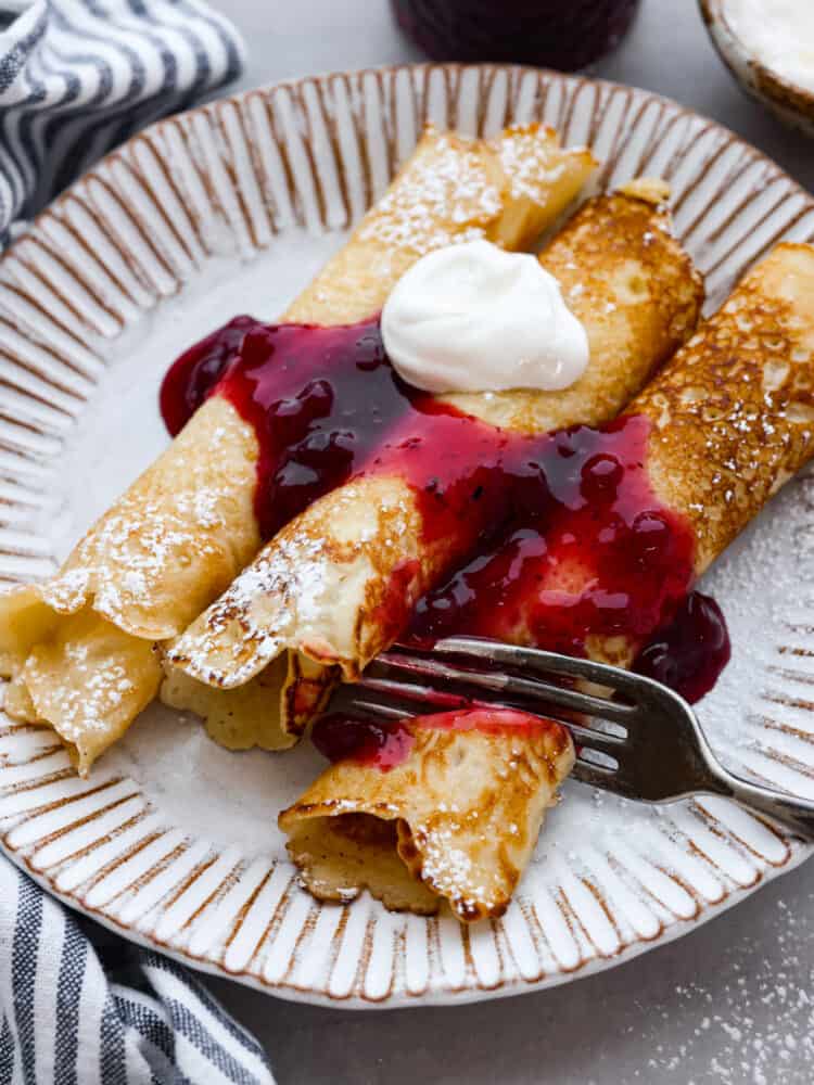 Homemade Swedish pancakes are the ultimate breakfast treat! They're soft, tender, and even better when topped with fresh whipped cream and lingonberry jam. 3 rolled Swedish pancakes served with lingonberry sauce and cream.