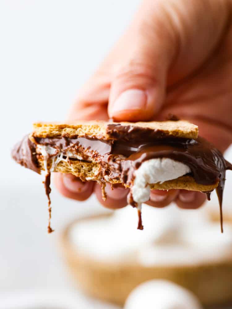 S'mores made easy in the air fryer! In just 7 minutes you'll have the most ooey-gooey air fryer smores, no campfire required! It's a quick and easy recipe you'll want to make all summer long. Closeup of melted chocolate and marshmallow.