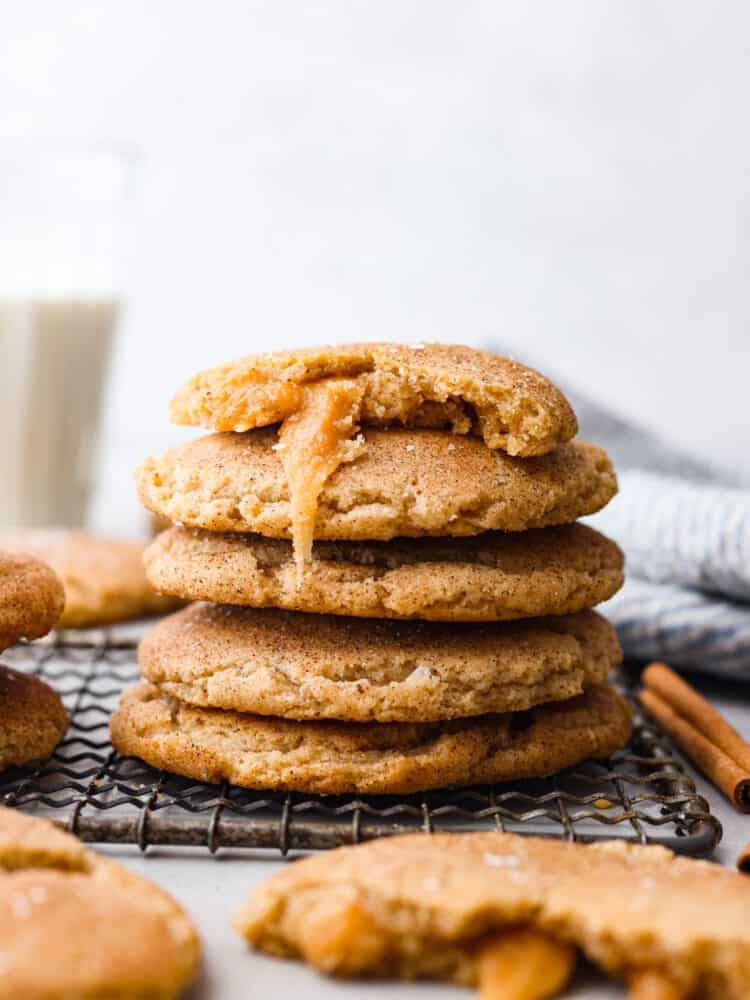 This recipe takes snickerdoodles to the next level! Made with brown butter and a salted caramel core, each bite is a sweet and nutty dream! 5 snickerdoodles stacked on top of each other. There is a bite taken out of one of them so the caramel filling can be seen.
