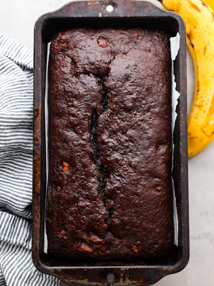Chocolate banana bread is a sweet and decadent banana bread made for chocolate lovers! Extra moist from the ripe bananas, and loaded with rich chocolate flavors from the cocoa powder and chocolate chips. Top view of chocolate banana bread baked in a loaf pan.