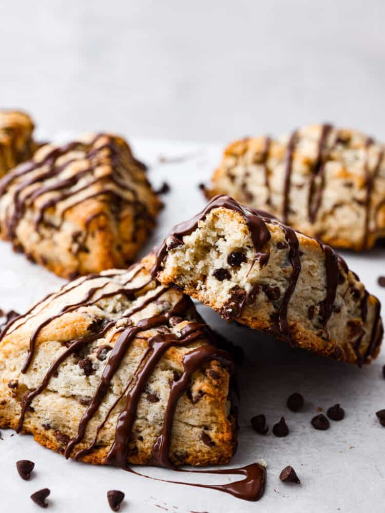 Chocolate chip scones are downright delicious. Theyโre buttery and soft, with pockets of chocolate chips for a melty surprise in each bite. These homemade scones are great for an on-the-go breakfast or an afternoon snack when youโre craving something sweet! 2 scones, one with a bite taken out of it.