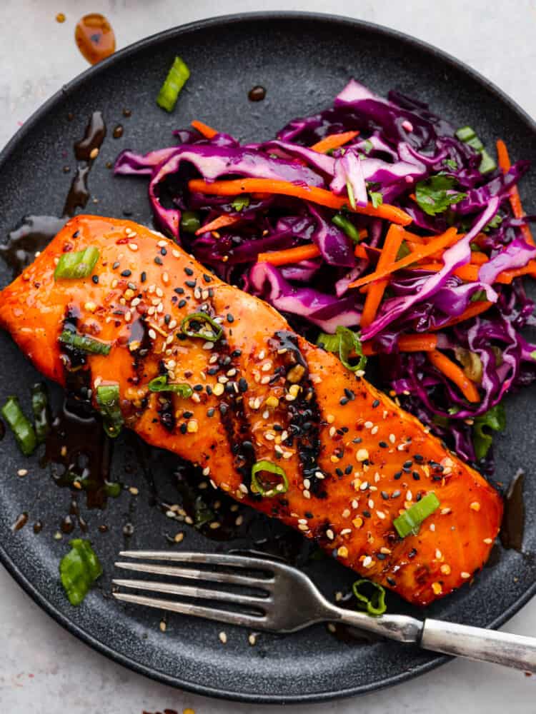 Ignite your taste buds with this incredible firecracker salmon! The fish is extra tender and flaky, coated in a delicious homemade glaze. Firecracker salmon served with red cabbage slaw.