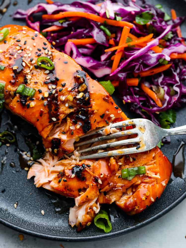 Ignite your taste buds with this incredible firecracker salmon! The fish is extra tender and flaky, coated in a delicious homemade glaze. Taking a bite of firecracker salmon.