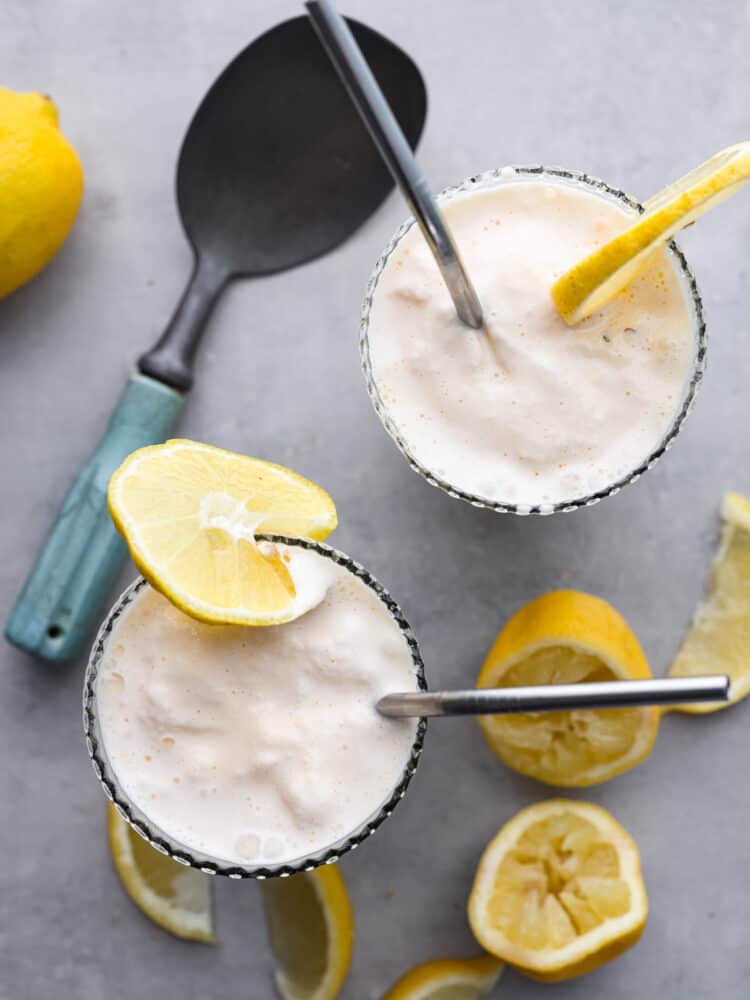 This Copycat Chick Fil A Frosted Lemonade is a delicious and creamy cold drink for the summer. This copycat frozen lemonade is so refreshing and perfect for hot days! The top view of a frosted lemonade with lemon sliced scattered around the cup.