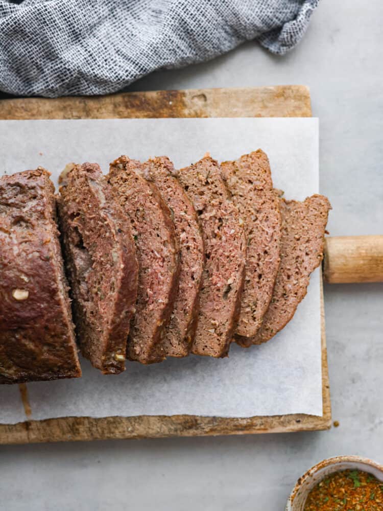 My easy-to-make gyro meat is perfectly seasoned and tender every time! Just like your favorite Mediterranean restaurant. Perfect for pitas, bowls, or platters with all your favorite toppings. Sliced gyro meat on a wooden board.