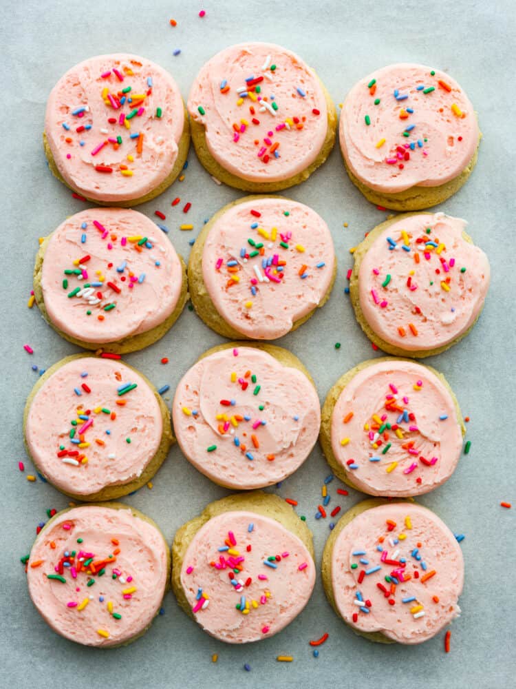 These classic Lofthouse Sugar Cookies are soft and puffy cake-like sugar cookies that taste just like the original! Topped with homemade buttercream frosting and rainbow sprinkles, these cookies will bring your right back to your childhood! The top view of 12 loft house sugar cookies ready to eat.