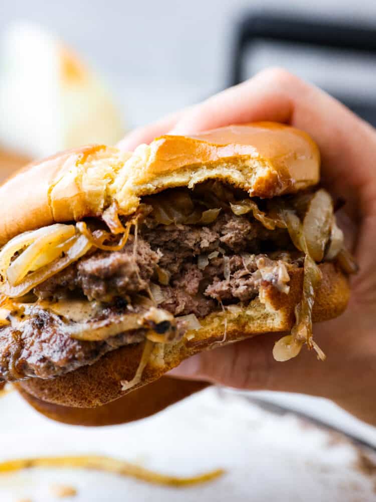 Oklahoma fried onion burgers are packed with so much flavor, thanks to each patty being stamped with heaps of sweet and savory caramelized onions! With how easy to make and delicious they are, you wonโt want burgers any other way. A burger with a bite taken out of it.