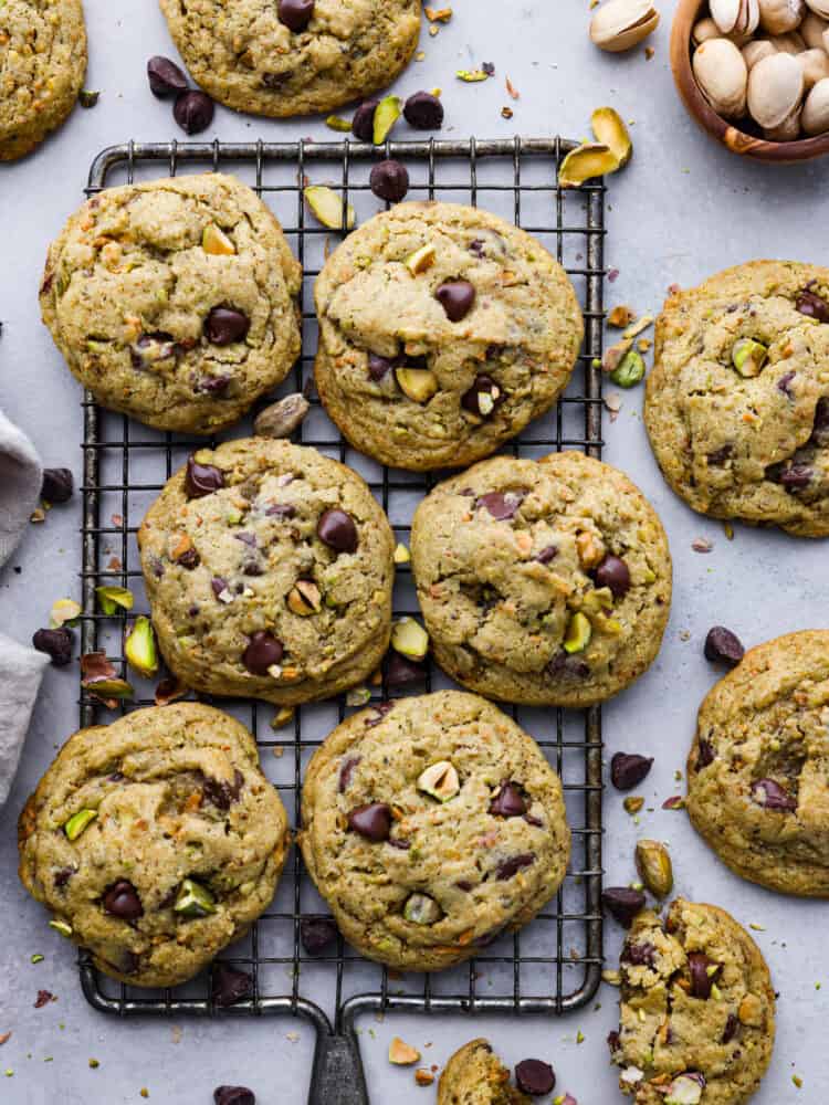 Nutty, sweet, and soft, these chocolate chip pistachio cookies are a must-try dessert! They're super easy to whip up and absolutely irresistible. Top-down view of pistachio cookies on a cooling rack.