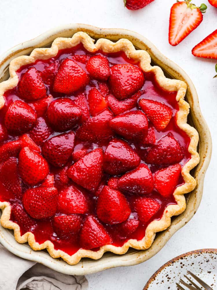 This easy and fresh strawberry pieย features sweet, juicy strawberries, and a flaky, homemade crust all covered in juicy berry glaze. Top-down view of a whole strawberry pie.
