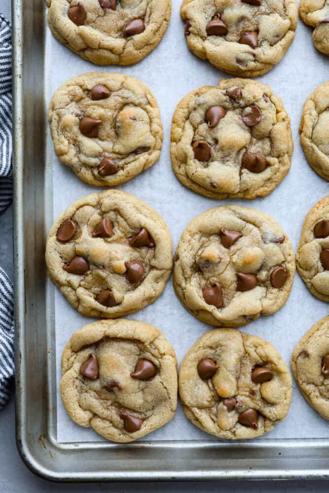 These are the Best Chocolate Chip Cookies that turn out perfectly every single time and don't require any chilling. This is a classic tried and true chocolate chip cookie recipe that you will make again and again! Chocolate chip cookies baked on parchment paper on a baking sheet.