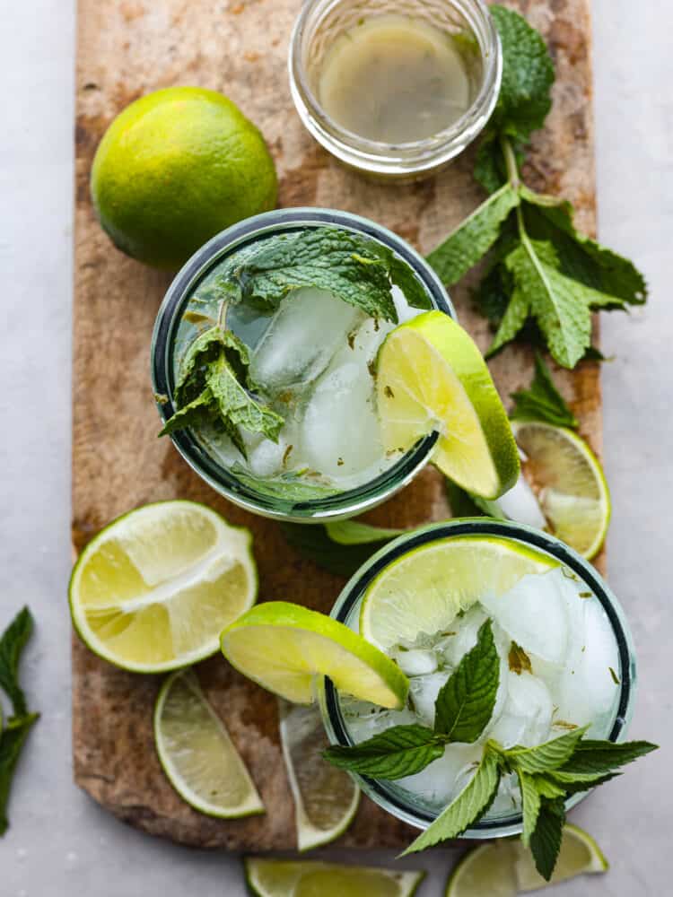 My Virgin Mojito is like a vacation in a glass. Crisp, minty, and packed with fresh lime flavor. This non-alcoholic drink is something my whole family loves! Top-down view of mojitos on a serving board.