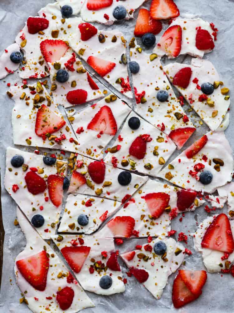 Frozen yogurt bark is SO easy to make and beyond delicious! Load it up with your favorite toppings for a summer treat that’s both tasty and healthy. Hero image of frozen yogurt bark broken into pieces.