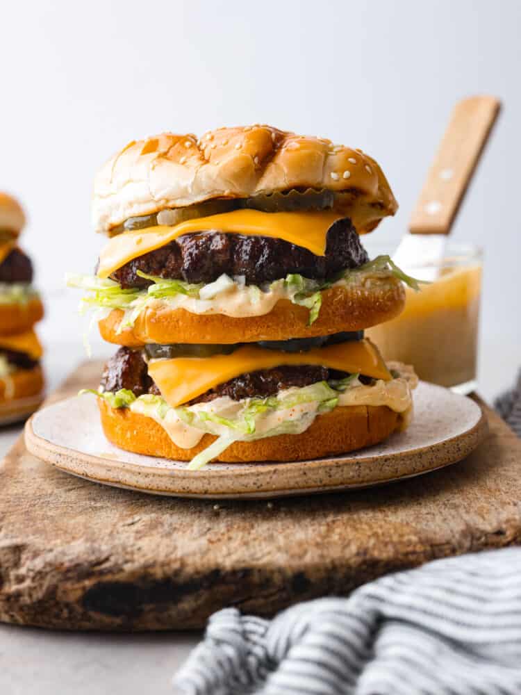 Two juicy all-beef patties, special sauce, lettuce, cheese, pickles, and onions all on sesame seed buns! You'll love recreating this copycat Big Mac burger at home. A homemade Big Mac burger on a stoneware plate.