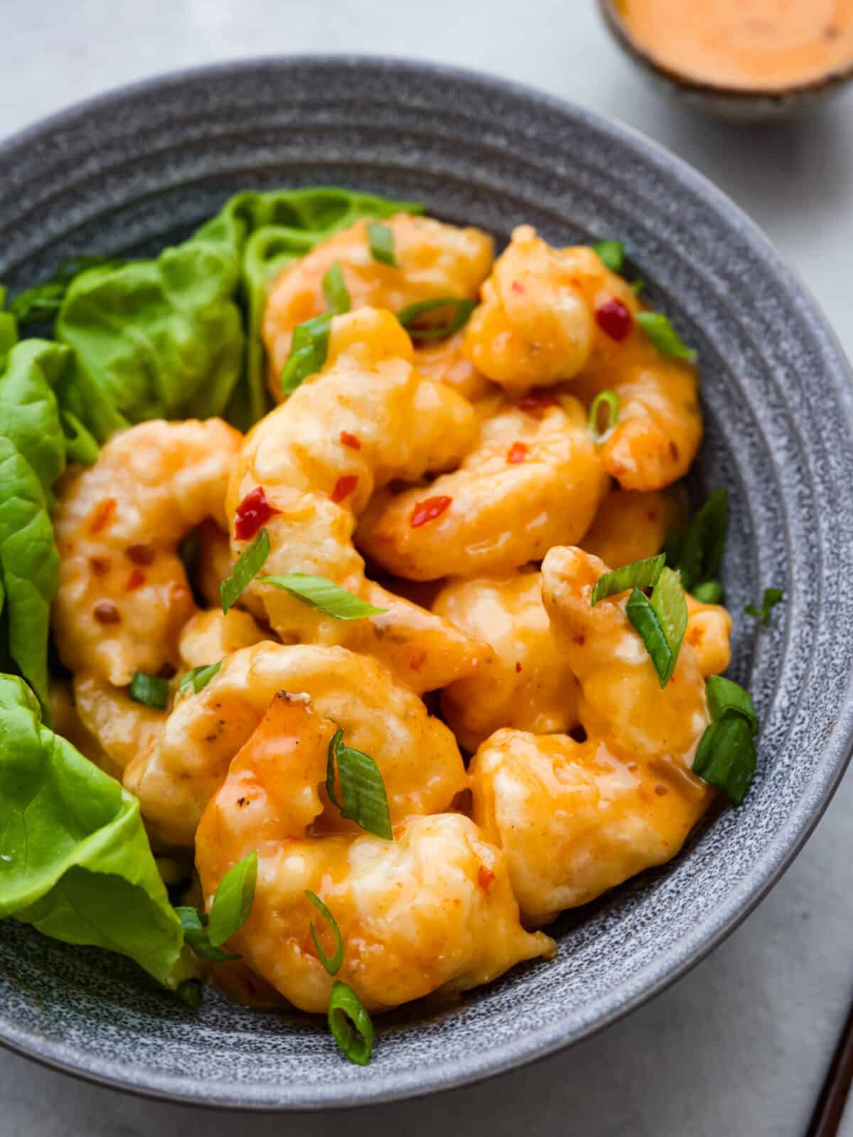Shake up dinnertime with this dynamite shrimp! Itโs fried to golden-brown, crispy perfection and tossed in a creamy, spicy sauce. Your family will be begging for seconds! Closeup of dynamite shrimp.