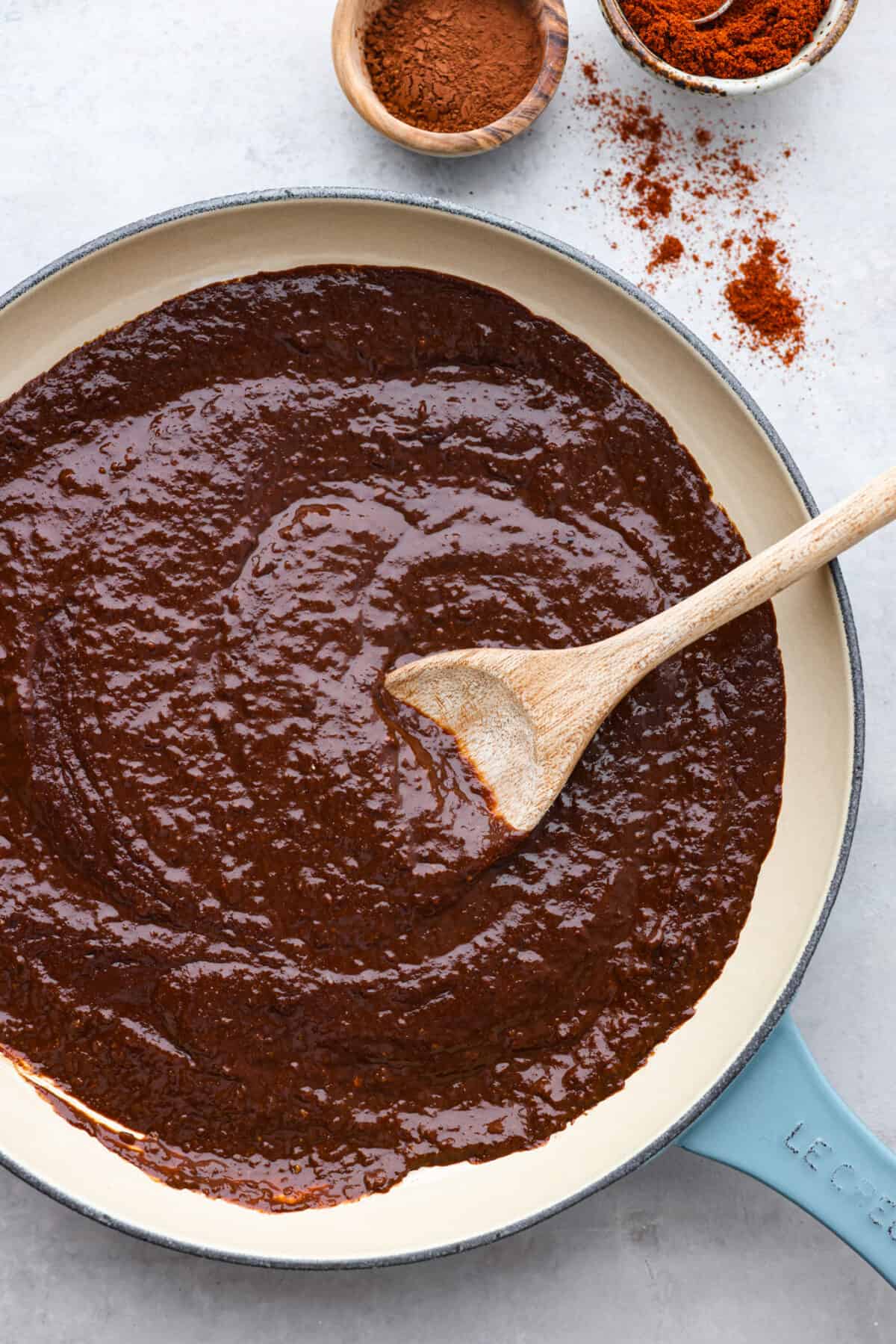 Meet mole, the Mexican sauce that's a tasty blend of spices, from cumin's earthiness to chipotle's kick. What really sets it apart is the touch of cocoa powder added for a little sweet richness. It's the best blend of flavors, you're going to love it! Mole sauce in a blue and white skillet.