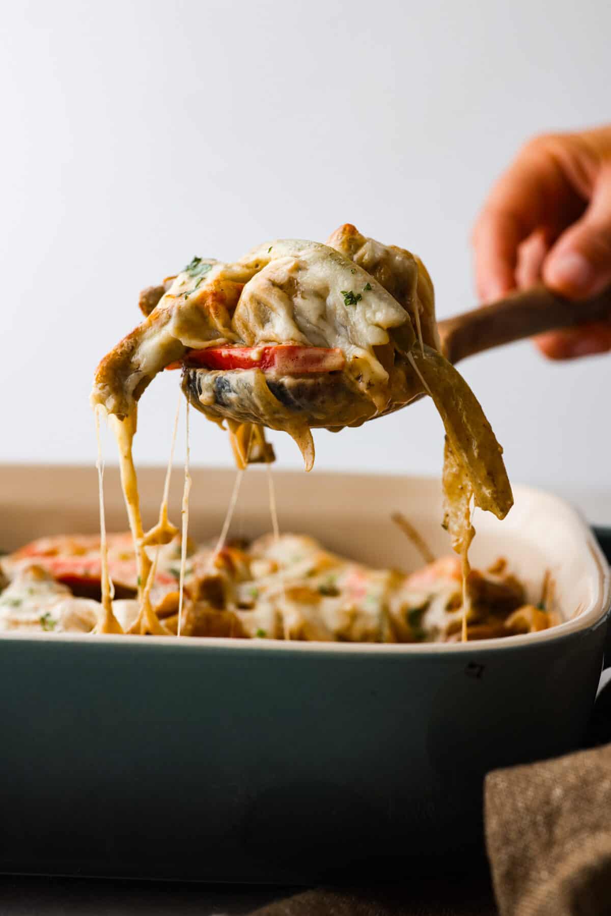 Try this delicious Philly Cheesesteak Casserole, a twist on the classic Philly Cheesesteak. Tender sirloin steak, colorful veggies, and creamy cheese come together for a mouthwatering meal the whole family will love! The side view of a spoon scooping out Philly cheesesteak casserole.