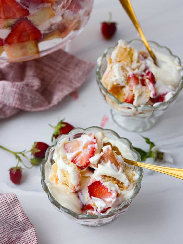 Get ready to dig into this amazing strawberry trifle! Layers of juicy strawberries, creamy cheesecake, and fluffy pound cake come together to create the ultimate summer dessert! Strawberry trifle in 2 dessert serving dishes.
