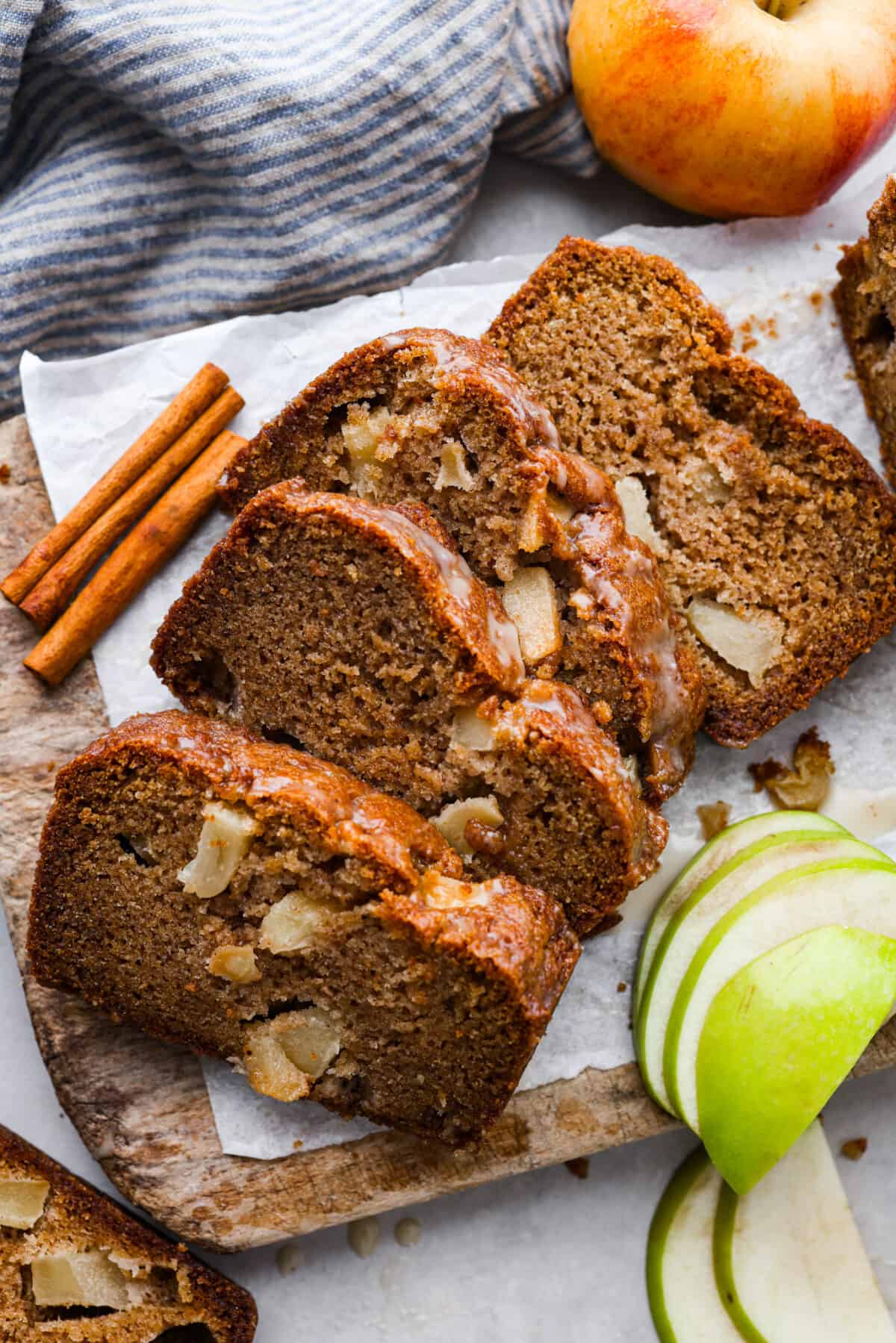 This deliciously sweet apple bread with hints of seasonal spices is a the perfect fall dessert. Each bite is packed with chunks of apple and hints of cinnamon and vanilla. Make this your new fall favorite indulgence. Top-down view of bread cut into 4 thick slices.