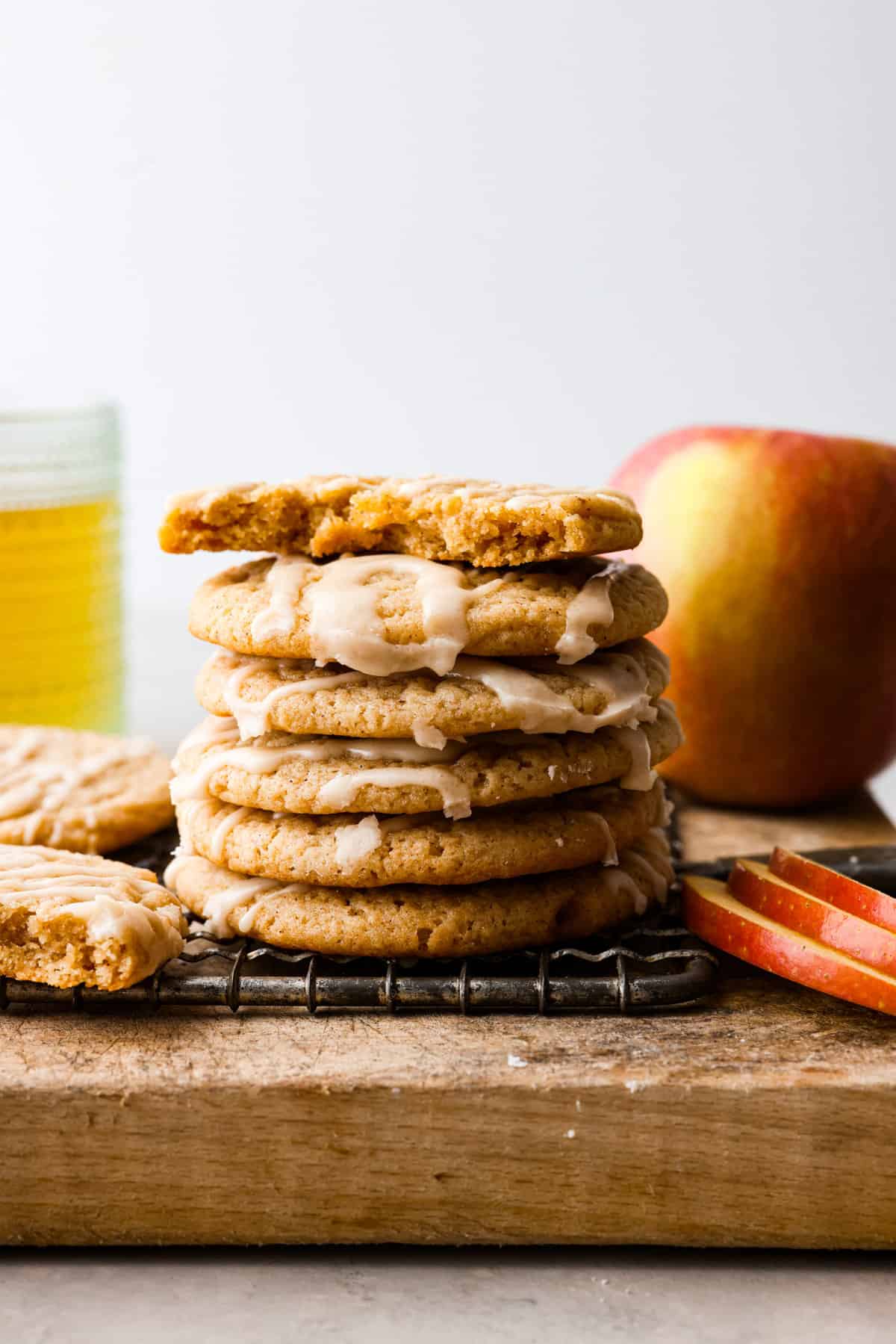 These soft and delicious Apple Cider Cookies are a delightful blend of apple cider, warm spices, and drizzled with a sweet glaze. These cookies are a cozy and irresistible treat that's perfect for any occasion. A stack of apple cider cookies.