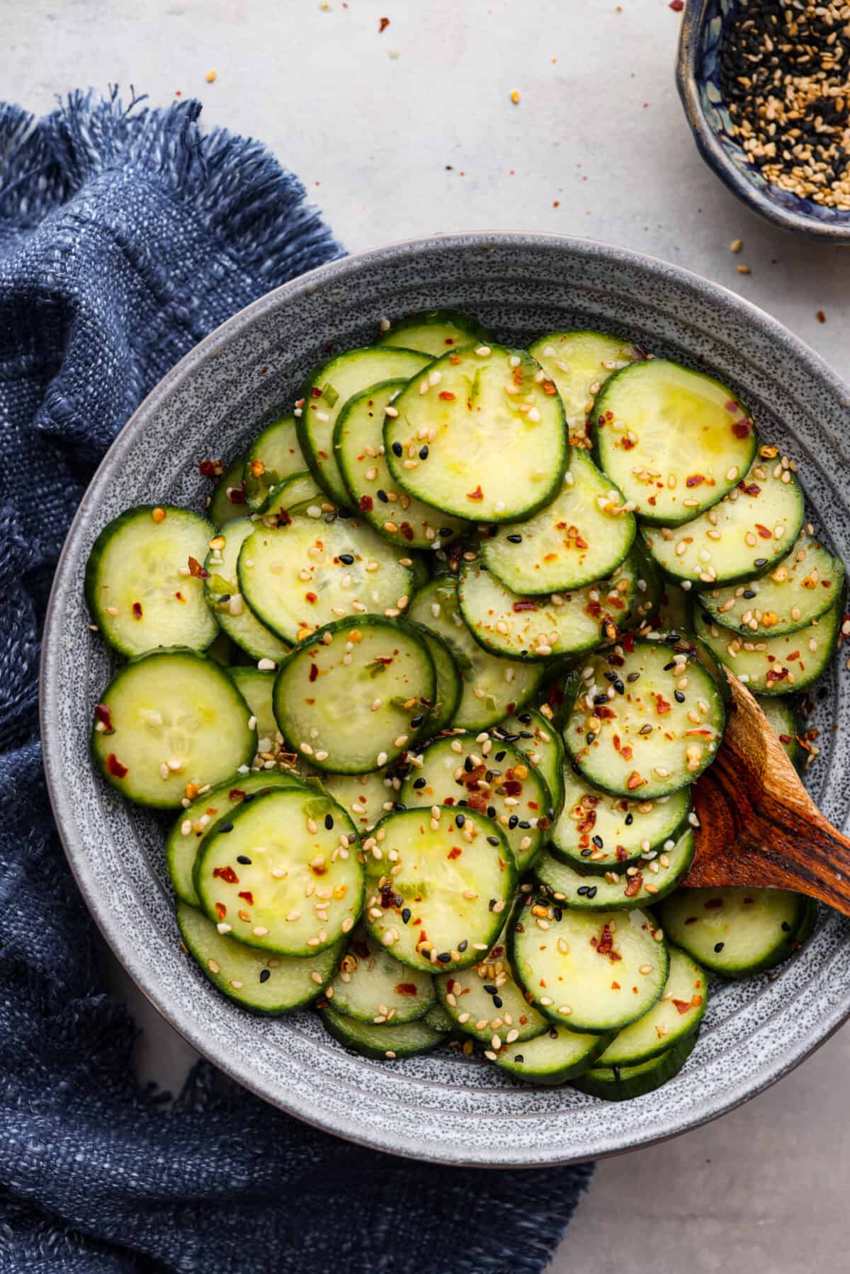 This delightful Asian Cucumber Salad is a blend of flavors creating a refreshing dish that's finished with a sprinkle of red pepper flakes and sesame seeds. It makes the perfect snack or side dish to complement any meal. A bowl of Asian Cucumber Salad.