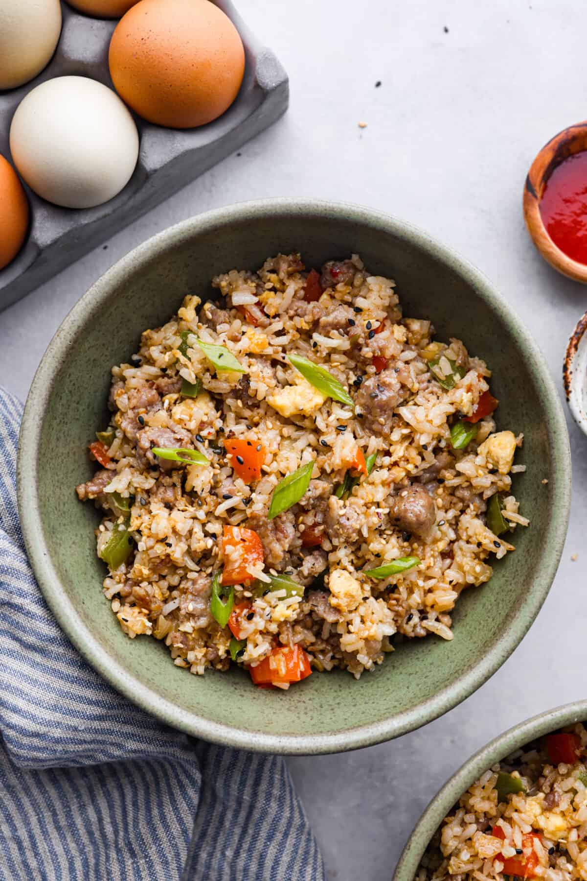 Upgrade your breakfast with this simple Breakfast Fried Rice. Sausage, eggs, and colorful bell peppers mix with white rice, all seasoned for a tasty kick. Top it off with green onions and everything bagel seasoning. A bowl of breakfast fried rice.