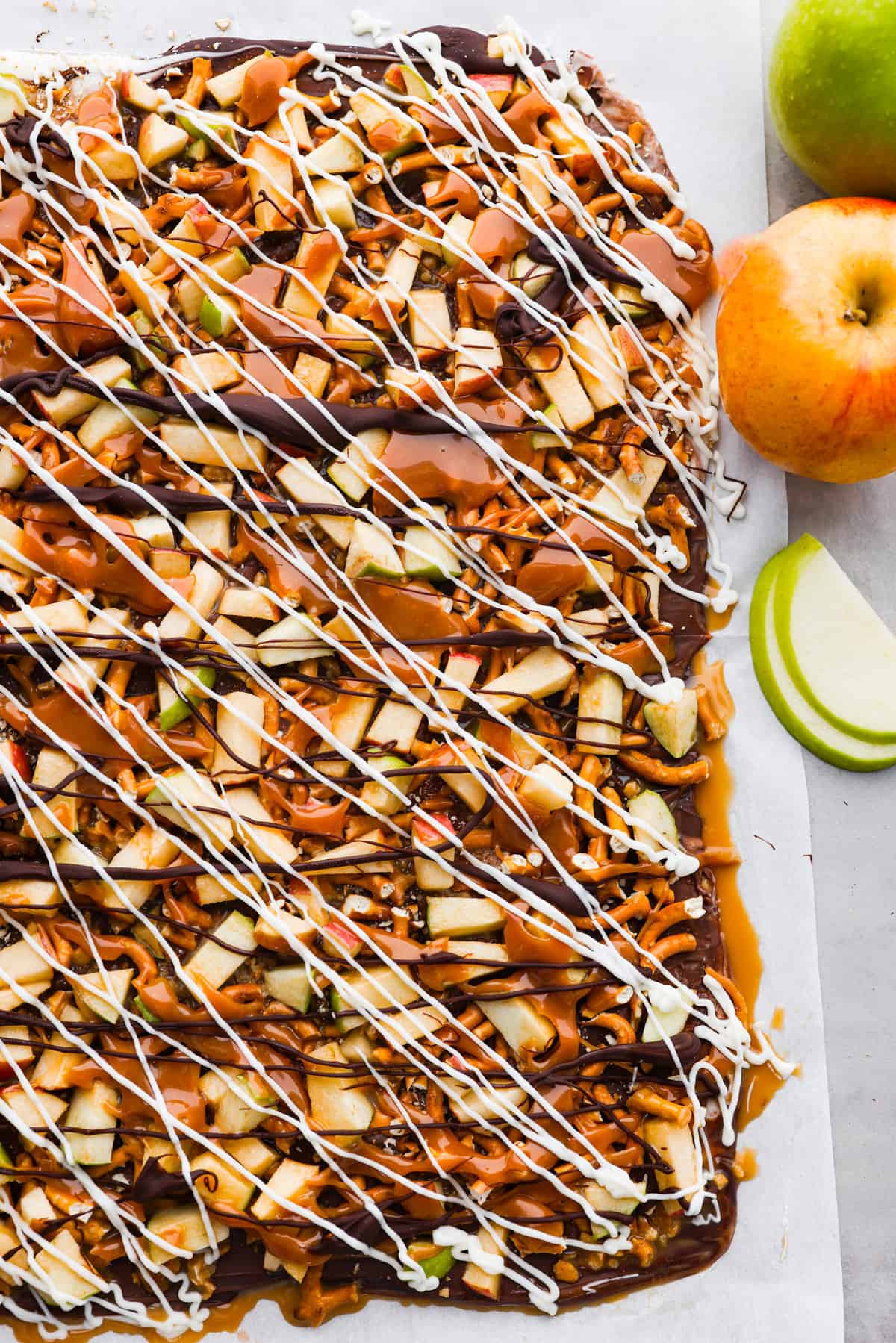 Meet your new favorite fall treat: caramel apple bark made with pretzels and a mix of white and dark chocolate! Itโs rich and sweet with the perfect crunch. One bite and youโll be hooked! Top-down view of caramel apple bark that hasn't been broken into pieces yet.