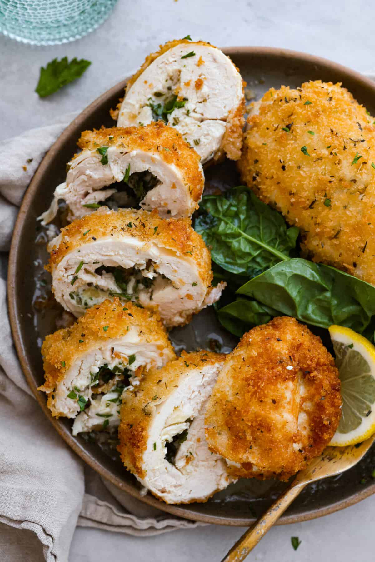Level up dinnertime with this crispy Chicken Kiev! Each piece of chicken is filled with herby compound butter, then coated in bread crumbs and fried to create a golden crust. Crispy on the outside, extra moist and flavorful on the inside, this is the perfect dinner for any occasion. Chicken Kiev cut into slices.