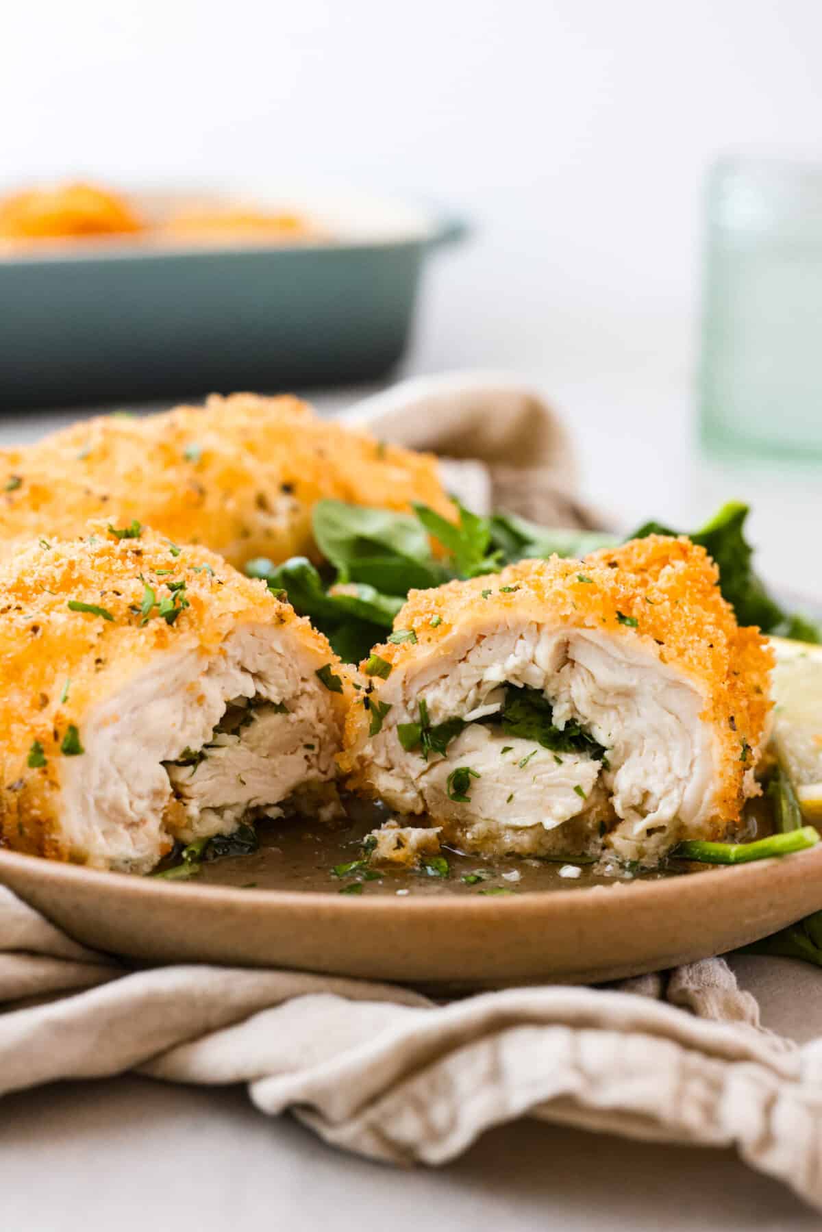 Level up dinnertime with this crispy Chicken Kiev! Each piece of chicken is filled with herby compound butter, then coated in bread crumbs and fried to create a golden crust. Crispy on the outside, extra moist and flavorful on the inside, this is the perfect dinner for any occasion. A piece of chicken Kiev, cut in half.