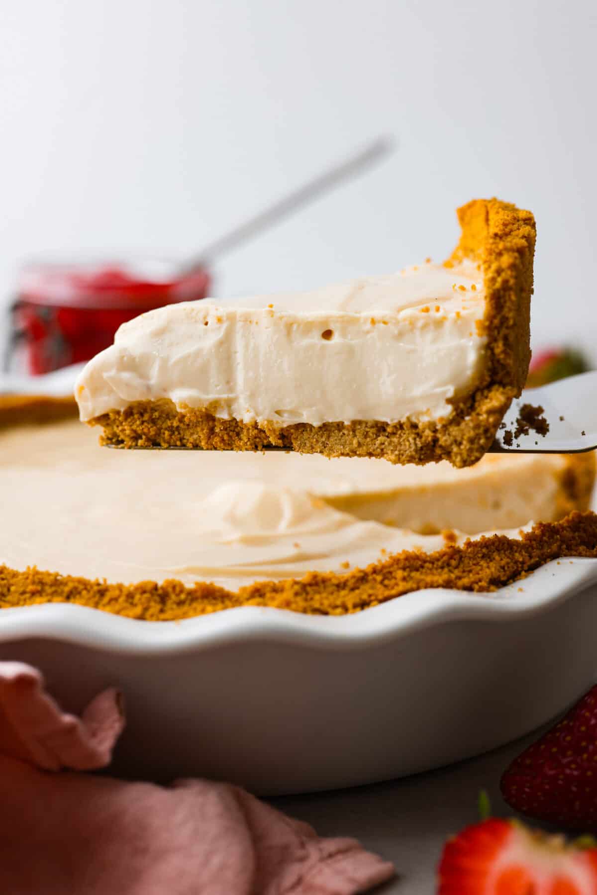 Experience pure dessert delight with this Cream Cheese Pie! A buttery graham cracker crust with a smooth cream cheese filling, and just a touch of lemon and vanilla. It's so easy and simply delicious. A slice of cream cheese pie being served.