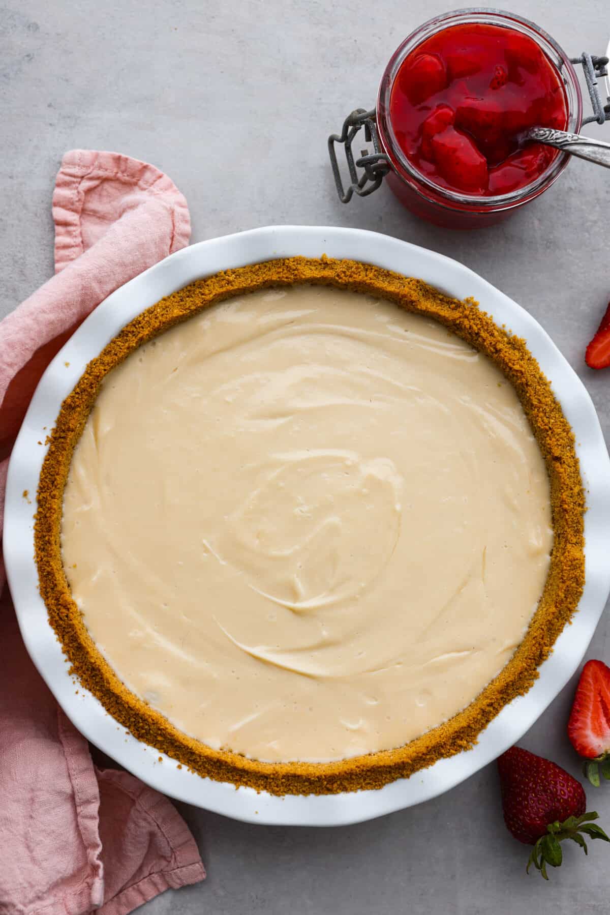 Experience pure dessert delight with this Cream Cheese Pie! A buttery graham cracker crust with a smooth cream cheese filling, and just a touch of lemon and vanilla. It's so easy and simply delicious. The top view of a cream cheese pie.