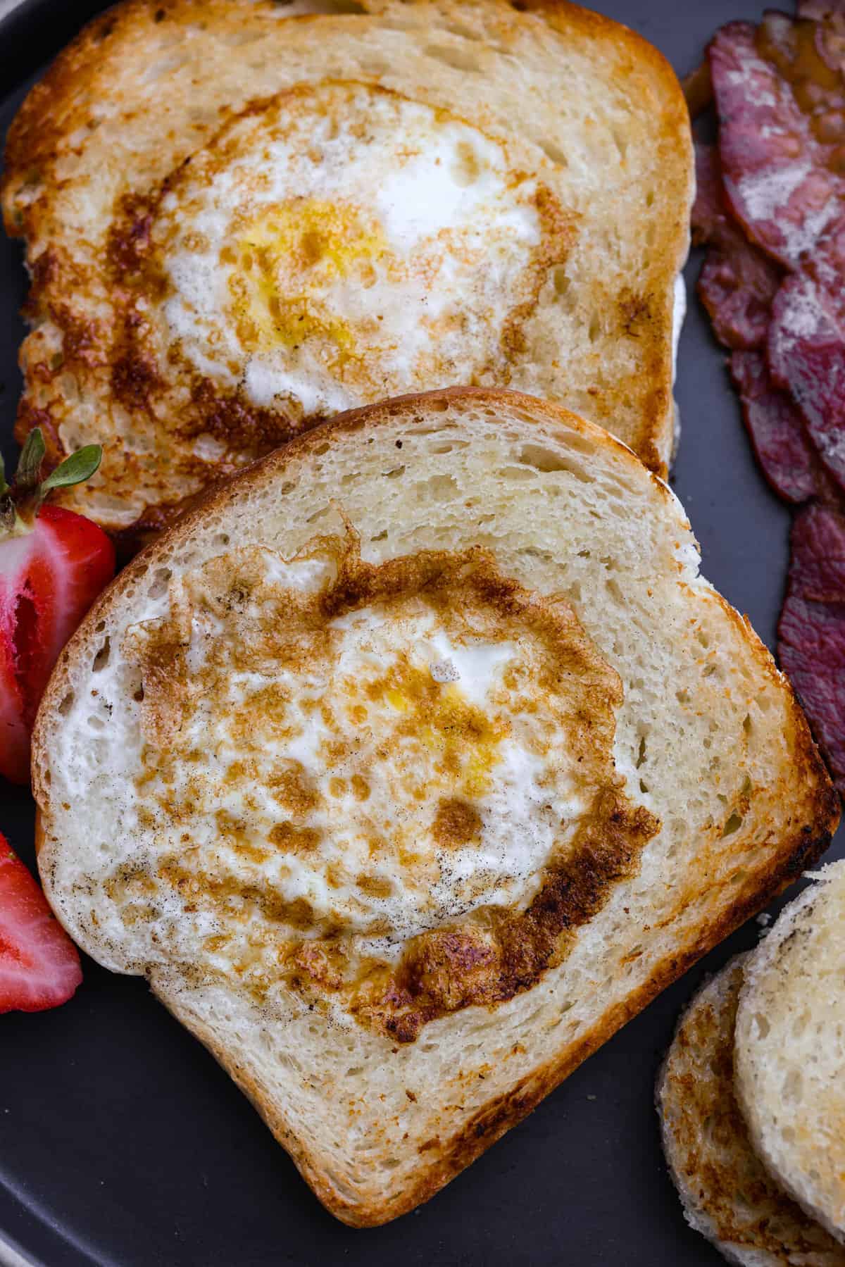 The ultimate all-in-one breakfast, here is how you can make the best "egg in a hole!" This easy dish is all about that crispy, buttery toast hugging those perfectly fried eggs. It's the most simple and delicious way to start off your morning! Closeup of egg-in-a-hole.