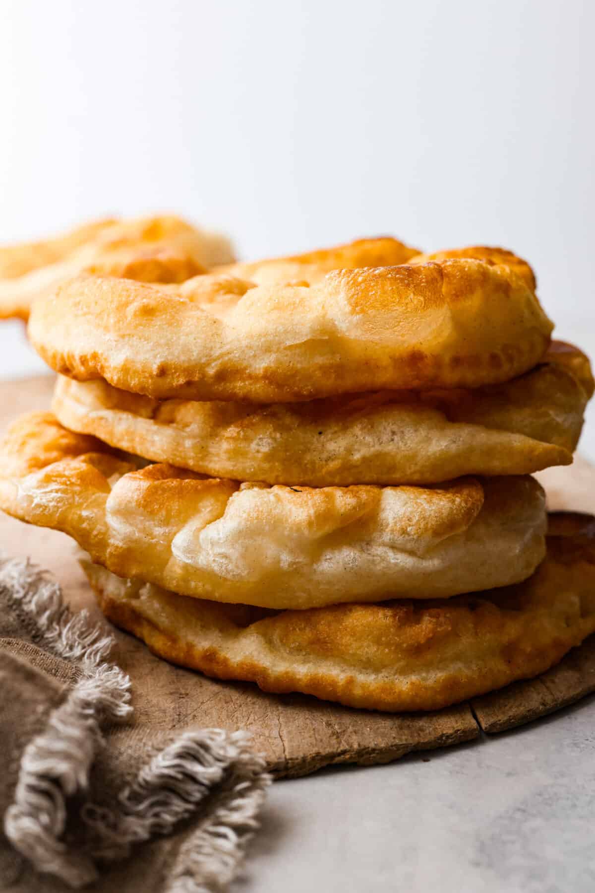 The perfect combination of airy, soft, and chewy, you NEED this homemade fry bread in your life! It's so versatile. You can enjoy it as-is, or use it as a canvas for all kinds of tasty sweet and savory creations. 3 pieces of fry bread stacked on top of each other.